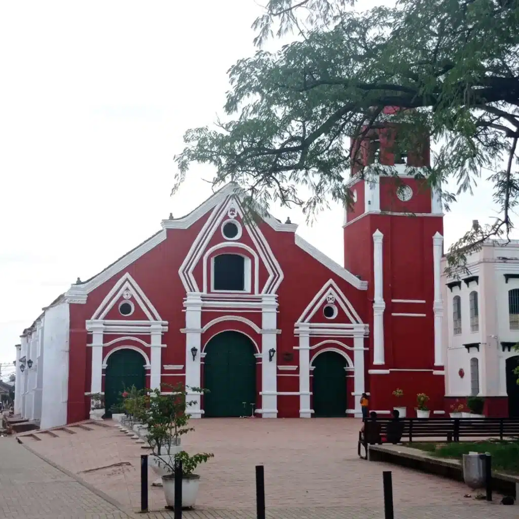 Colonial red-and-white Santa Bárbara Church facade with clock tower in Mompox, Bolívar, Colombia